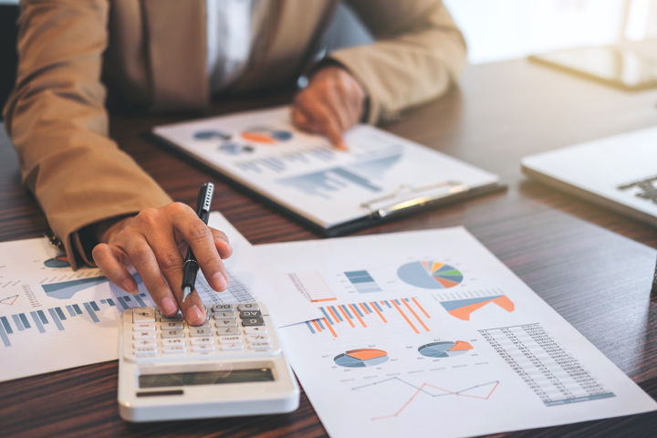 Planning-His right hand is on the calculator, and his left hand is calculating the report data