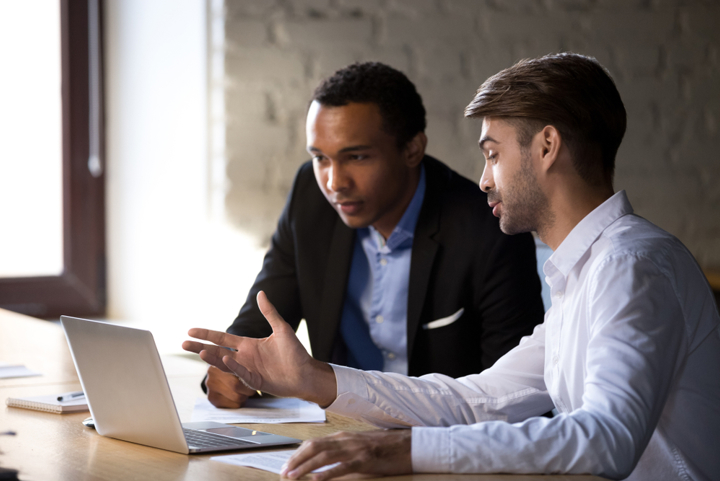 A sales meeting around a computer screen