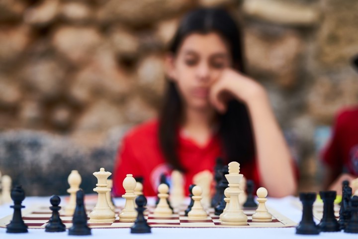 La fille regarde l'échiquier dans un état second